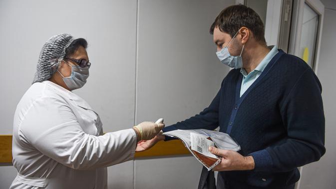 Seorang pria diperiksa suhu tubuhnya sebelum mendapat suntikan vaksin COVID-19 di Moskow, Rusia, pada 8 Desember 2020. Sejak dimulainya program vaksinasi massal di Moskow pada 5 Desember, sekitar 2.000 orang dari kelompok berisiko tinggi telah disuntik vaksin. (Xinhua/Evgeny Sinitsyn)