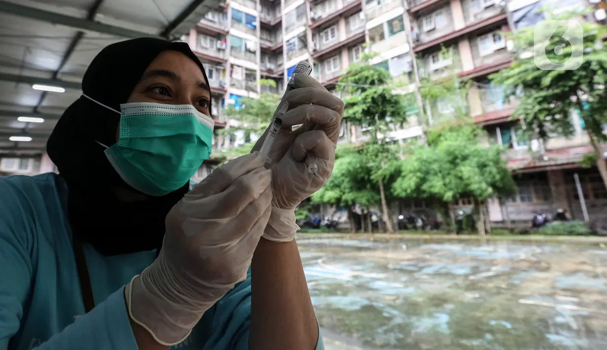 Petugas menyiapkkan vaksin COVID-19 dosis ketiga (booster)  untuk warga di RPTRA Rusun Benhil, Jakarta, Rabu (6/7/2022). Selain itu, vaksin booster juga jadi syarat bagi masyarakat yang ingin melakukan perjalanan menggunakan transportasi umum. (Liputan6.com/Johan Tallo)