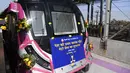 Bunga menghiasi bagian depan kereta metro tanpa pengemudi pertama India di stasiun metro saat peresmiannya di New Delhi, Senin (28/12/2020). Kereta tanpa pengemudi itu akan beroperasi di jalur magenta sepanjang 38 kilometer di ibu kota India yang menghubungkan 25 stasiun metro. (Sajjad HUSSAIN/AFP)