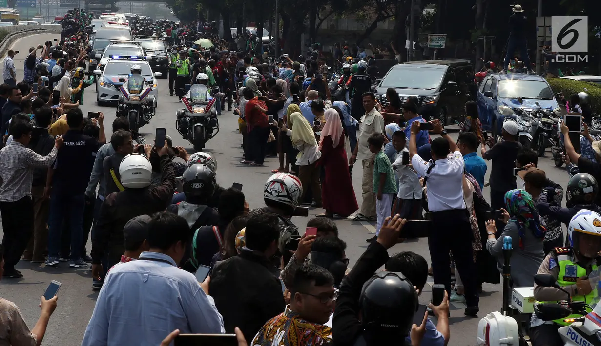 Iring-iringan mobil jenazah yang membawa almarhum Presiden ke-3 RI, BJ Habibie melintasi Jalan Gatot Subroto menuju TMP Kalibata, Jakarta, Kamis (12/9/2019). Warga secara khusus meluangkan waktu menyambut jenazah BJ Habibie untuk memberikan penghormatan terakhir. (Liputan6.com/Johan Tallo)