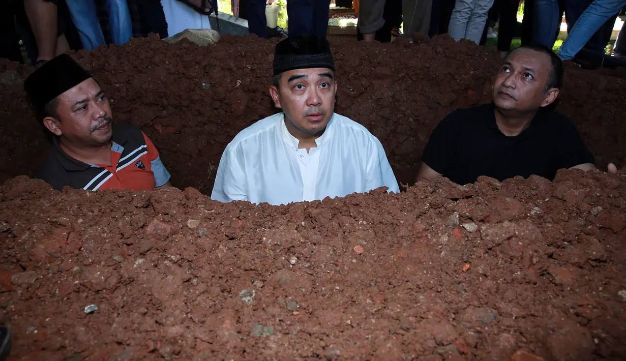 Jenazah Kiki dimakamkan  di TPU Tanah Kusir, Jakarta Selatan pada Senin (21/12/2015). Farhan sendiri menyambut jenazah putranya tersebut di liang lahat. Usai meletakkan jenazah, ia pun segera mengumandangkan azan dan iqomah. (Deki Prayoga/Bintang.com)