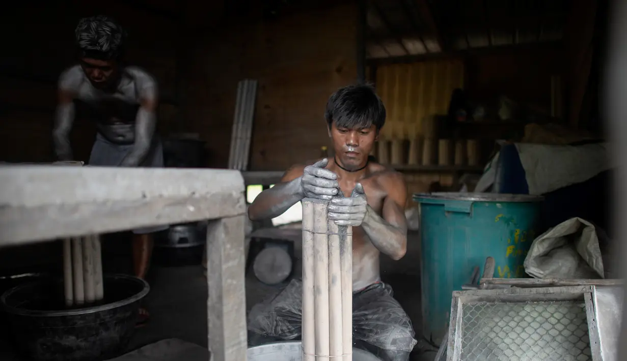 Pekerja memasukan bubuk mesiu ke dalam selongsong saat membuat kembang api untuk perayaan Tahun Baru 2019 di Bocaue, Bulacan, Manila Utara (26/12). (AFP Photo/Noel Celis)