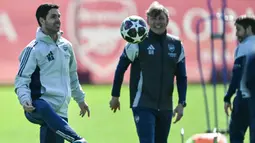 Di atas kertas, Arsenal lebih diunggulkan. Diketahui, tim racikan pelatih asal Spanyol, Mikel Arteta, belum terkalahkan dalam 10 pertandingan di Liga Champions musim ini. Tampak dalam foto, Manajer Arsenal asal Spanyol, Mikel Arteta (kiri), menendang bola saat sesi latihan tim di pusat pelatihan Arsenal di London Colney, utara London, pada Senin 6 April 2026. (Glyn KIRK/AFP)