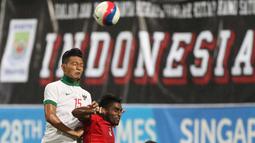 Pemain Indonesia U-23, Agung Prasetyo (kiri), berebut bola dengan pemain Singapura U-23. (Bola.com/Arief Bagus)