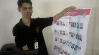Salahs eorang petugas KPUD Garut menunjukan lembar surat suara cacat akibat tinta yang tembus dan merusak halaman (Liputan6.com/Jayadi Supriadin)