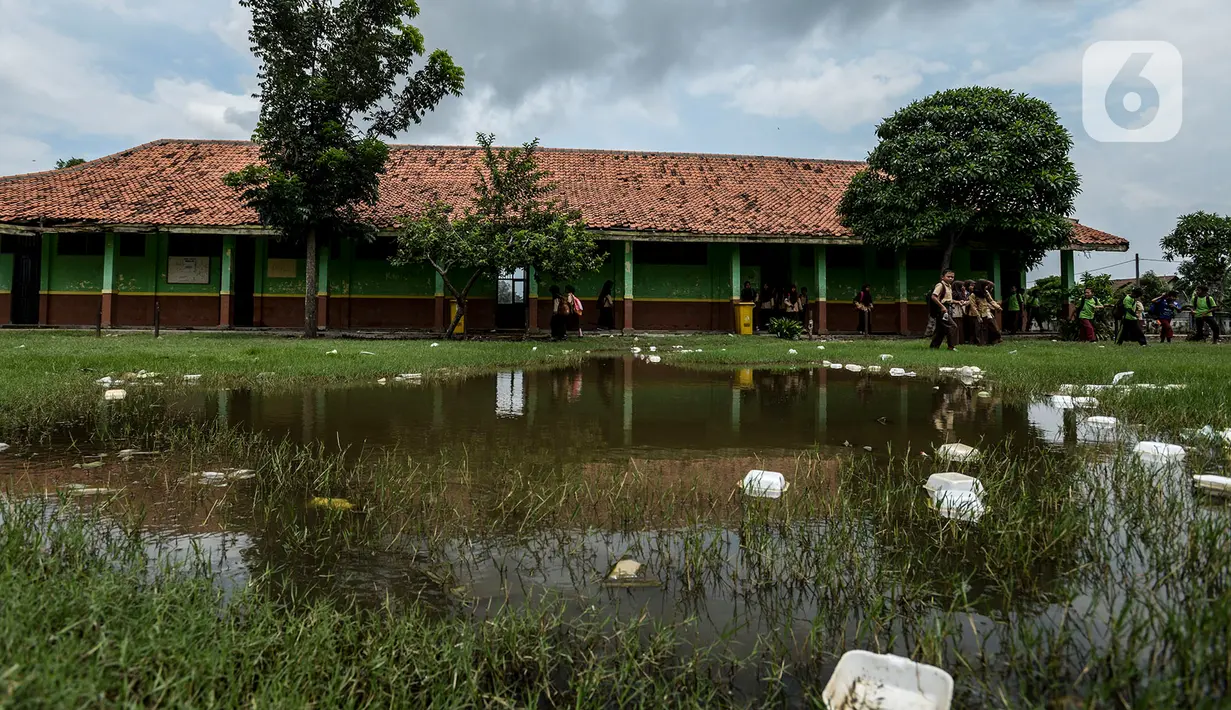 Kondisi halaman SDN Samudrajaya 04 saat tergenang air, Desa Samudrajaya, Kecamatan Tarumajaya, Kabupaten Bekasi, Jawa Barat, Selasa (21/1/2020). Murid SDN Samudrajaya 04 terpaksa belajar di gedung sekolah yang rusak sejak tahun 2014. (merdeka.com/Imam Buhori)