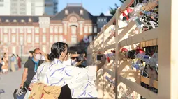 Seorang pengunjung memotret lonceng angin di sebuah pameran dekat Stasiun Tokyo di Tokyo, Jepang (26/8/2020). Lebih dari 2.000 lonceng angin dipajang selama pameran yang berlangsung dari 21 Agustus hingga 28 Agustus itu. (Xinhua/Du Xiaoyi)