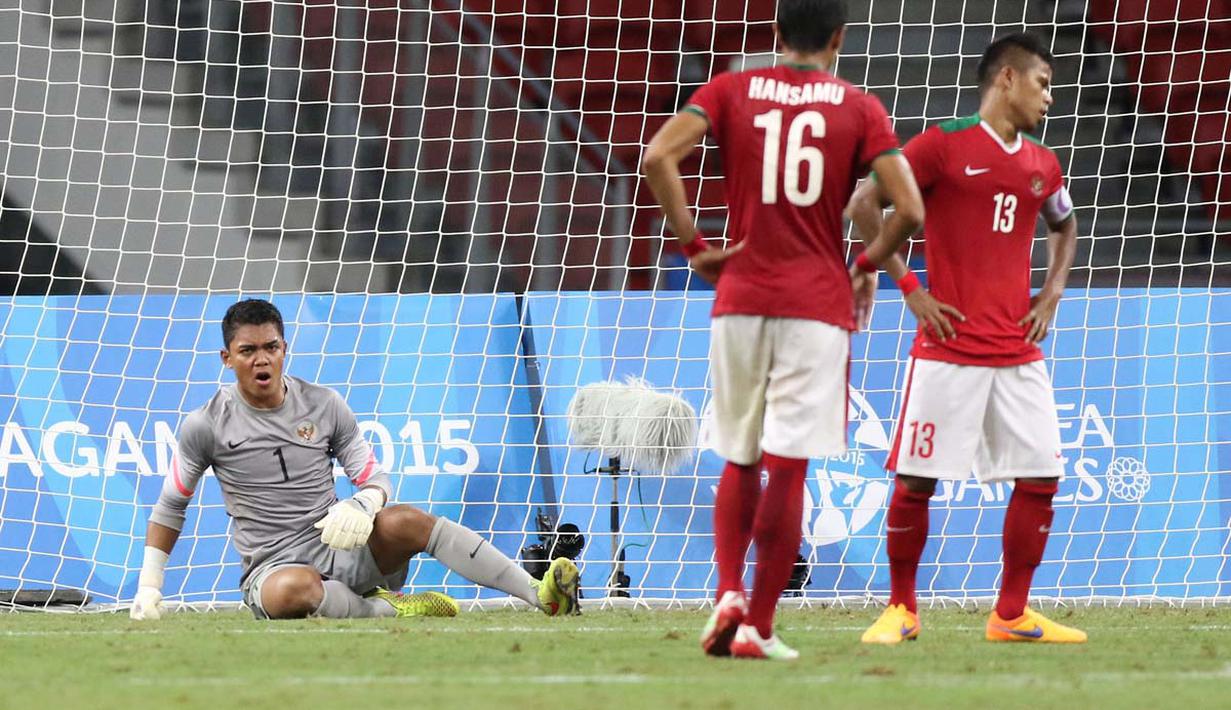 Ekspresi kiper Indonesia U-23, Teguh Amiruddin, setelah gawangnya kebobolan oleh pemain Thailand U-23 dalam semi final sepak bola SEA Games 2015 di Stadion Nasional, Singapura. Sabtu (13/6). (Bola.com/Arief Bagus)