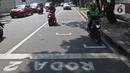 Pembatas Jarak Bagi Pengendara Motor: Pengendara motor berhenti pada garis pembatas antarpengendara di kawasan Hang Tuah Raya, Jakarta, Selasa (16/6/2020). Garis itu untuk membatasi jarak antarpengendara guna mencegah penyebaran COVID-19. (Liputan6.com/Herman Zakharia)