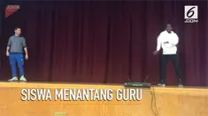 Seorang siswa menantang gurunya menari di depan murid-murid lain.