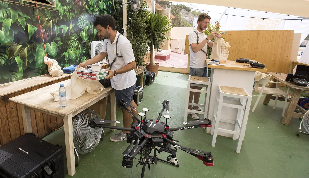 Pilot drone menyiapkan kantong makanan untuk dilampirkan ke drone dari Cala Tadira dekat Sant Josep de Sa Talaia di Pulau Ibiza, Spanyol, 24 Agustus 2021. Layanan Drone to Yacht untuk mengirim makanan dan minuman eksklusif ke kapal pesiar diluncurkan di Ibiza. (JAIME REINA/AFP)