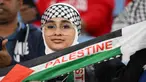 Seorang pendukung memegang syal sebelum dimulainya pertandingan sepak bola Grup C Piala Asia AFC Qatar 2023 antara Palestina dan Uni Emirat Arab di Stadion Al-Janoub di Al-Wakrah, Doha pada 18 Januari 2024. (HECTOR RETAMAL/AFP)