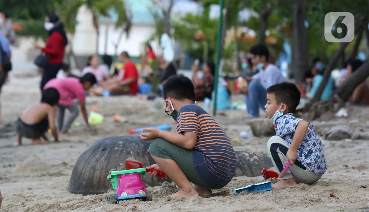 Anak-anak bermain pasir di Pantai Indah Taman Impian Jaya Ancol, Jakarta, Kamis (29/10/2020). Libur panjang di masa pemberlakuan PSBB transisi Jakarta dimanfaatkan warga untuk mengunjungi lokasi-lokasi wiisata. (Liputan6.com/Helmi Fithriansyah)