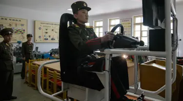 Siswa berlatih mengendarai simulator kendaraan militer di Sekolah Revolusioner Mangyongdae, 10 April 2018. Didirikan oleh pendiri Korea Utara, Kim Il Sung untuk mendidik anak-anak yatim piatu yang orangtuanya terbunuh dalam perang Jepang. (ED JONES/AFP)