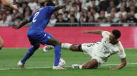 Pertandingan Liga Spanyol 2023/2024 antara Real Madrid kontra Getafe hari Sabtu (02/09/2023). Tampak Jude Bellingham (kanan) terjatuh usai duel melawan pemain Getafe, Djene Dakonam. (Thomas COEX / AFP)