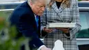 Presiden Donald Trump bersama Melania Trump meletakkan batu dari Gedung Putih di monumen peringatan penembakan maut di sinagog Tree of Life, Kota Pittsburgh, Pennsylvania, AS, Selasa (30/10). (AP Photo/Andrew Harnik)