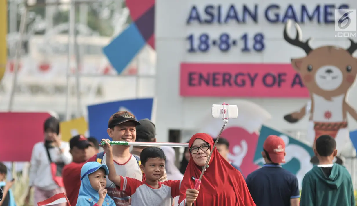 Warga berselfie saat menyaksikan lomba lari maraton putri Asian Games 2018 di kawasan MH Thamrin, Jakarta, Minggu (26/8). (Merdeka.com/Iqbal S. Nugroho)