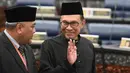 Pemimpin Partai Keadilan Rakyat Malaysia, Anwar Ibrahim melambaikan tangan sebelum mengambil sumpah jabatan dalam upacara pelantikan di Gedung Parlemen, Kuala Lumpur, Senin (15/10). Anwar Ibrahim dilantik sebagai anggota parlemen. (MOHD RASFAN/AFP)