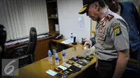 Sejumlah barang bukti telepon gengam diamankan saat operasi tangkap tangan (OTT) terkait pungutan liar perizinan kapal di Kementerian Perhubungan, Jakarta, Selasa (11/10). (Liputan6.com/Faizal Fanani)