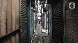 Aktivitas pedagang di dekat deretan kios yang tutup di Pasar Sumur Batu, Kemayoran, Jakarta, Rabu (8/7/2020). Dari 156 pedagang, hingga saat ini baru 30 orang yang mengikuti tes usap. (merdeka.com/Iqbal S. Nugroho)