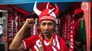 Pedagang mengenakan atribut timnas Indonesia jelang pertandingan AFF 2022 antara Indonesia melawan Thailand di Stadion Gelora Bung Karno, Jakarta, Kamis (29/12/2022). Atribut timnas Indonesia seperti kaos, syal, dan topi dijual dengan kisaran harga Rp35.000 hingga Rp75.000. (Liputan6.com/Faizal Fanani)