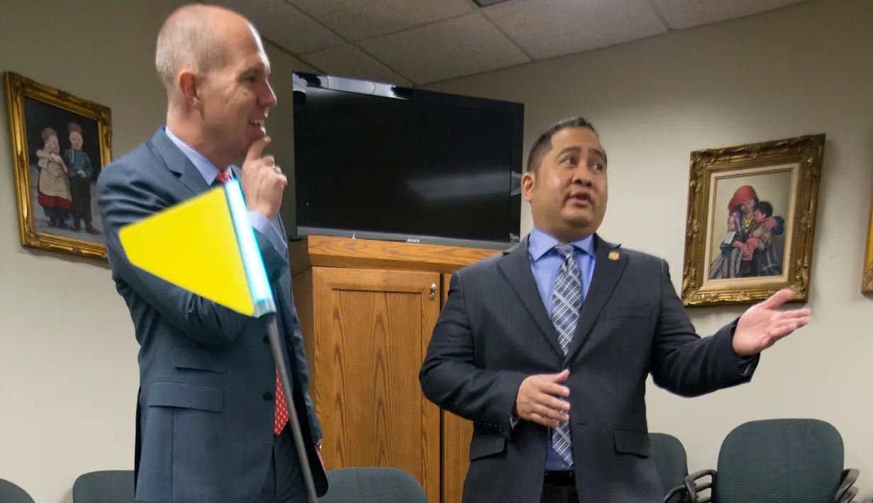 Ketua House Transportation Committee, Del. Ron Villanueva (kanan) sedang berbicara dengan kliennya, David Catania saat uji coba Robot Pengirim di Virginia, AS (25/1). Dengan hadirnya robot ini diharapkan dapat membantu manusia.(AP Photo/Steve Helber)