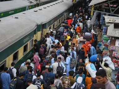Orang-orang menunggu kereta penumpang untuk pulang ke kampung halaman untuk Hari Raya Idul Fitri yang akan datang, sekaligus menandai berakhirnya bulan suci Ramadan, di sebuah stasiun kereta api di Karachi, Pakistan, Selasa 17 Maret 2026. Serupa dengan Indonesia, Pakistan memiliki tradisi mudik saat menyambut Hari Raya Idul Fitri. (AP Photo/Ali Raza)