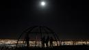 Sejumlah orang berfoto sambil menyaksikan fenomena Supermoon dari sebuah dataran tinggi di Ciudad Juarez, Meksiko, Minggu (16/10). Fenomena ini terjadi setiap tahun ketika orbit bulan berada berada dekat dengan bumi. (Reuters/Jose Luis Gonzalez)