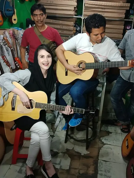 "Ini malam mingguku, mana malam minggumu?" tulis Arumi Bachsin sebagai keterangan foto. Wah romantis ya bermain gitar bersama orang tercinta. (Foto: instagram.com/arumi_arumi_94)