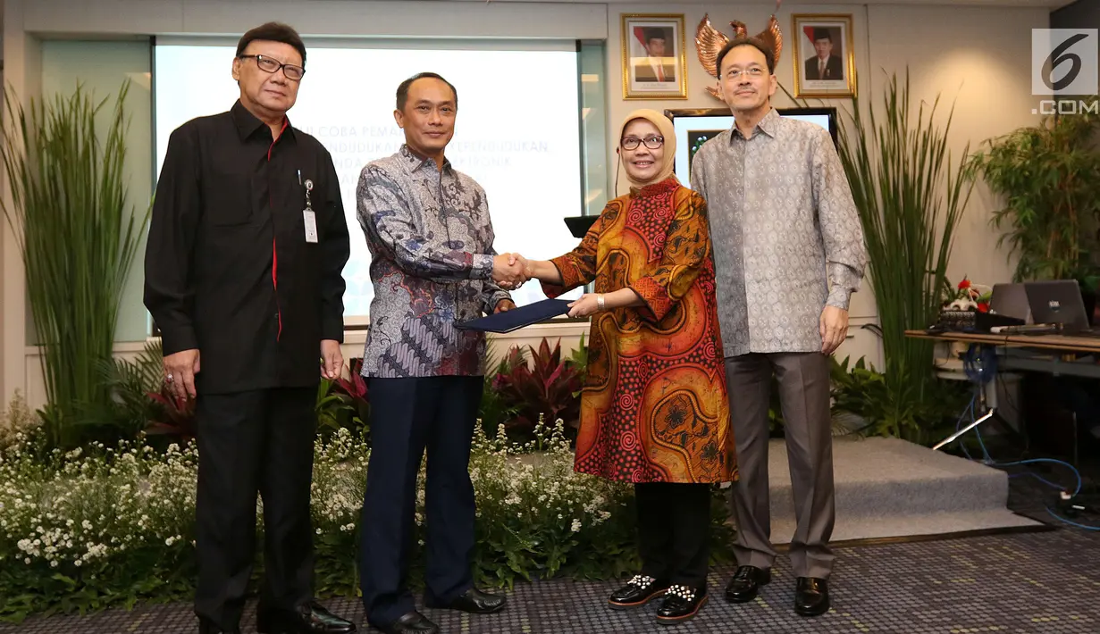 Dirjen Dukcapil, Zudan Arif Fakrulloh (kedua kiri) bersalaman dengan Direktur PT. Emtek Yuslinda Nasution (kedua kanan) disaksikan Komisaris Utama PT Emtek Eddy Sariaatmadja dan Mendagri Tjahyo Kumolo di Jakarta, Jumat (13/7). (Liputan6.com/Angga Yuniar)