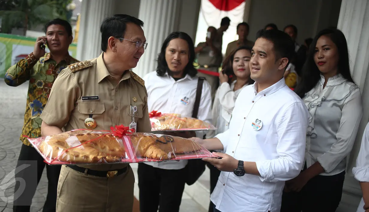 Koordinator relawan Ahok-Djarot, Dodi (kanan) memberikan roti buaya kepada Gubernur DKI Basuki Tjahaja Purnama di Balai Kota Jakarta, Senin (29/8). Roti buaya itu simbol warga meminang Ahok-Djarot pada Pilkada DKI Jakarta 2017 (Liputan6.com/Faizal Fanani)