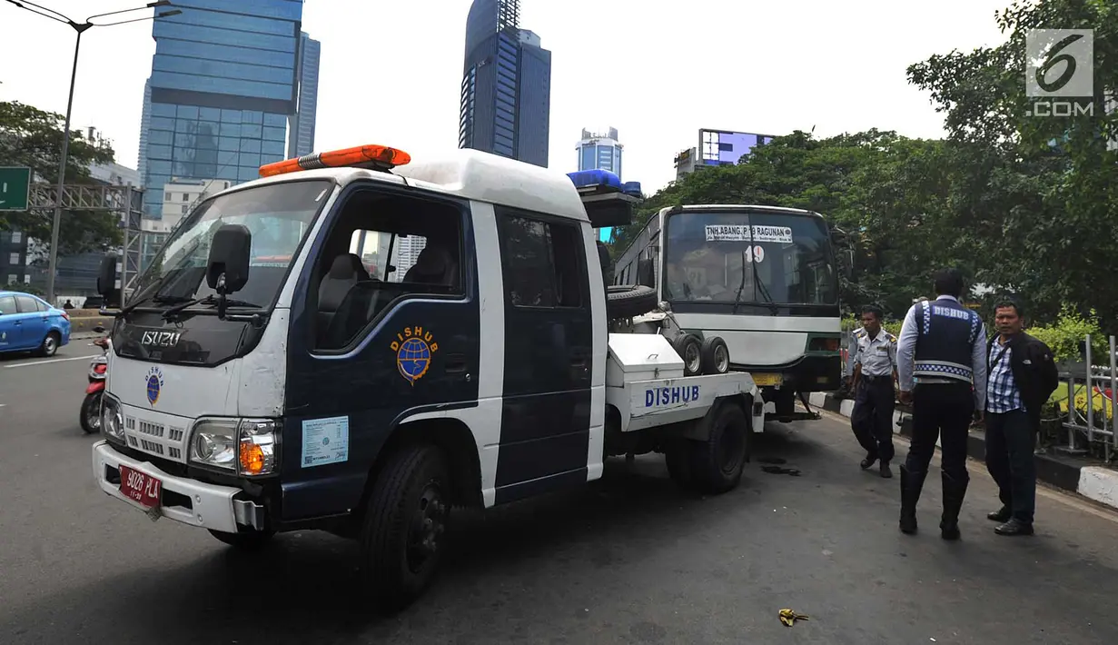 Petugas Dishub DKI Jakarta menderek bus Kopaja yang ngetem di kawasan Stasiun Sudirman, Jakarta (17/7). Dishub DKI melakukan razia rutin terhadap angkutan umum yang ngetem dan menyebabkan kemacetan  lalu lintas. (Merdeka.com/Arie Basuki)
