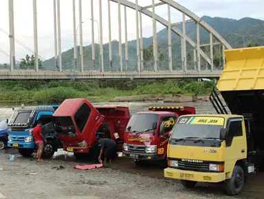 Sejumlah pemilik kendaraan memanfaatkan aliran sungai Bone untuk mencuci di kompleks Jembatan Talumolo II, Kelurahan Talumolo, Gorontalo, Senin (19/11). Tempat itu menjadi kawasan pencucian kendaraan bermotor yang gratis.  (Liputan6.com/Arfandi Ibrahim)