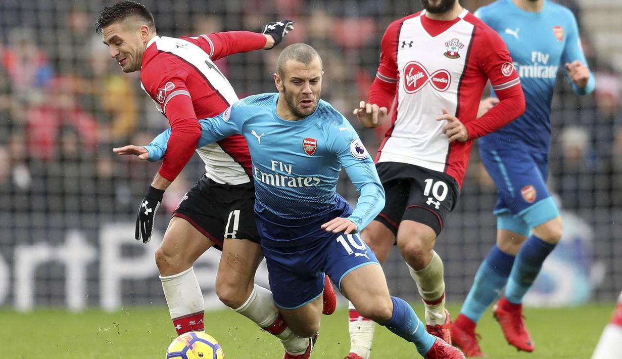 Gelandang Arsenal, Jack Wilshere, berebut bola dengan Gelandang Southampton, Dusan Tadic, pada laga Premier League di Stadion St Mary's, Minggu (10/12/2017). Arsenal bermain imbang 1-1 dengan Southampton. (AP/Adam Davy)