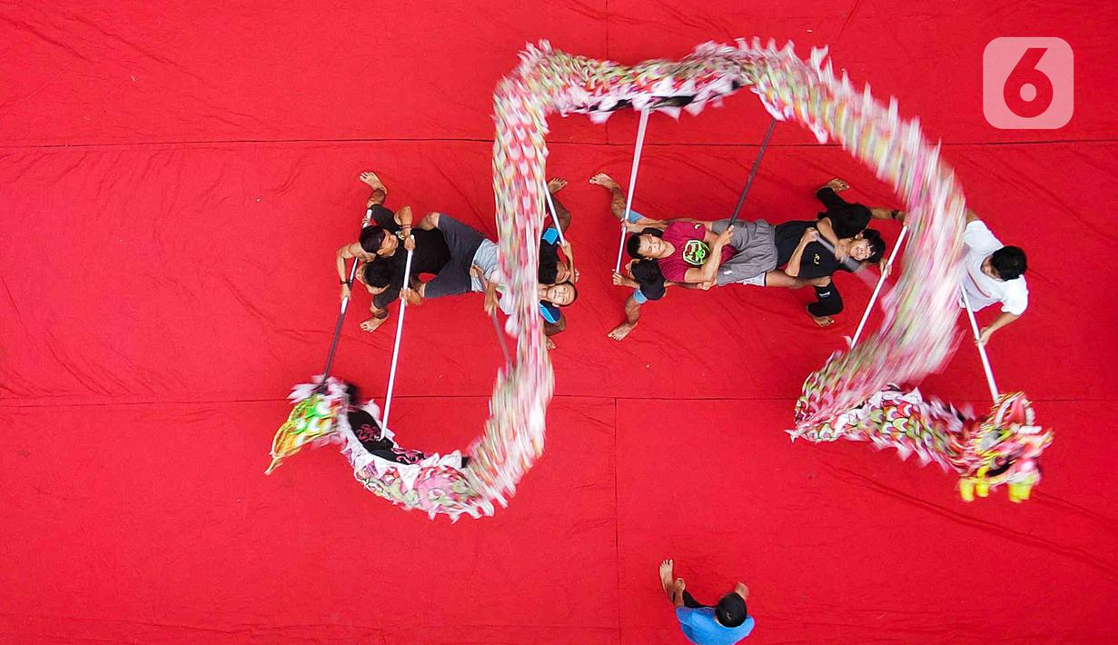 Pemain dari kelompok barongsai Naga Merah Putih Bogor melakukan latihan dengan Liong di kawasan Babakan Pasar, Kota Bogor, Jawa Barat, Rabu (11/1/2023). Latihan tersebut  untuk mempersiapkan penampilan menyambut Tahun Baru Imlek. (Liputan6.com/Herman Zakharia)