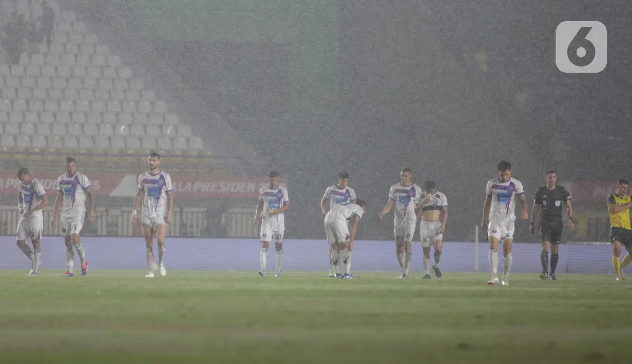 Hujan membuat sejumlah titik lapangan tergenang air, sehingga laga dihentikan sejenak dan panitia pelaksana menghilangkan genangan air. (Liputan6.com/Helmi Fithriansyah)