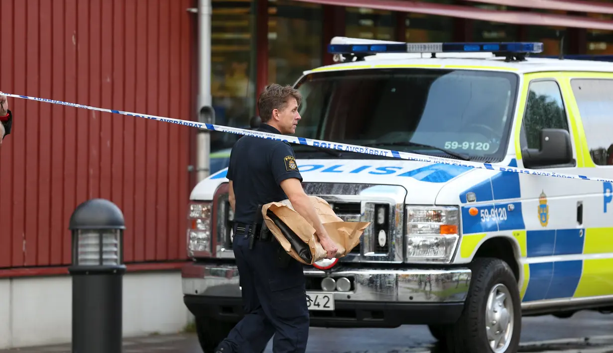 Petugas membawa barang bukti dari sekolah Kronan di Trollhattan, Swedia barat, Kamis (22/10). Seorang pria bertopeng dan bersenjatakan pedang menyerang sekolah tersebut dan menewaskan satu murid dan satu guru.(REUTERS/Bjorn Larsson Rosvall/TT News Agency)