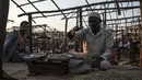 Penjual biji kopi hijau merapikan dagangannya di sebuah kios pasar lokal di Kota Asosa, Ethiopia, Rabu (25/12/2019). (EDUARDO SOTERAS/AFP)