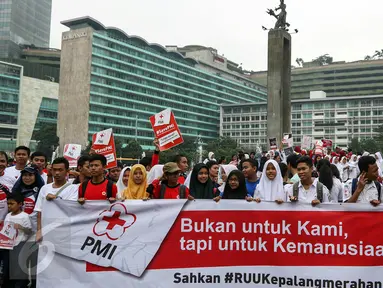 Ratusan sukarelawan Palang Merah Indonesia (PMI) gelar aksi di acara car free day, Bunderan HI, Jakarta, Minggu (6/3). Mereka mendesak DPR untuk mengesahkan RUU Kepalangmerahan menjadi UU Kepalangmerahan pada tahun 2016 ini.(Liputan6.com/Yoppy Renato)