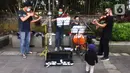 Musisi lokal Bogor memainkan musik klasik di pedestrian Kebun Raya, Jalan Pajajaran, Bogor, Jawa Barat, Minggu (14/6/2020). Untuk memenuhi kebutuhan hidup akibat sepinya job pertunjukan selama pandemi COVID-19, mereka memilih mengamen saat warga berolahraga. (merdeka.com/Arie Basuki)