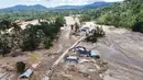 Warga berjalan di sepanjang jalan di sebuah desa yang terdampak banjir bandang di Batang Toru, Sumatera Utara, Senin 1 Desember 2025. Serangkaian bencana hidrometeorologi, yang mencakup banjir bandang (flash floods) dan tanah longsor dalam skala masif, menghantam beberapa wilayah di tiga provinsi di pulau Sumatera. (AP Photo/Binsar Bakkara)