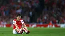 Gelandang Arsenal, Mesut Ozil, terduduk usai gagal memanfaatkan peluang mencetak gol ke gawang Besiktas di ajang play-off Liga Champions di Stadion Emirates, London, (28/8/2014). (REUTERS/Eddie Keogh)