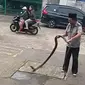 Engkong Cobra bersama king cobra 3 meter yang ditangkap di Padurenan, Mustikajaya Bekasi.(Liputan6.com/Bam Sinulingga)

 