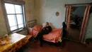 Mikhail Baburin (66) membaca buku sambil bersantai di rumahnya di desa Mikhailovka, Siberia, 5 Desember 2016. Baburin sangat menikmati hari tuanya di desa terpencil Mikhailovka, Siberia, tempat ia dilahirkan. (REUTERS/Ilya Naymushin)