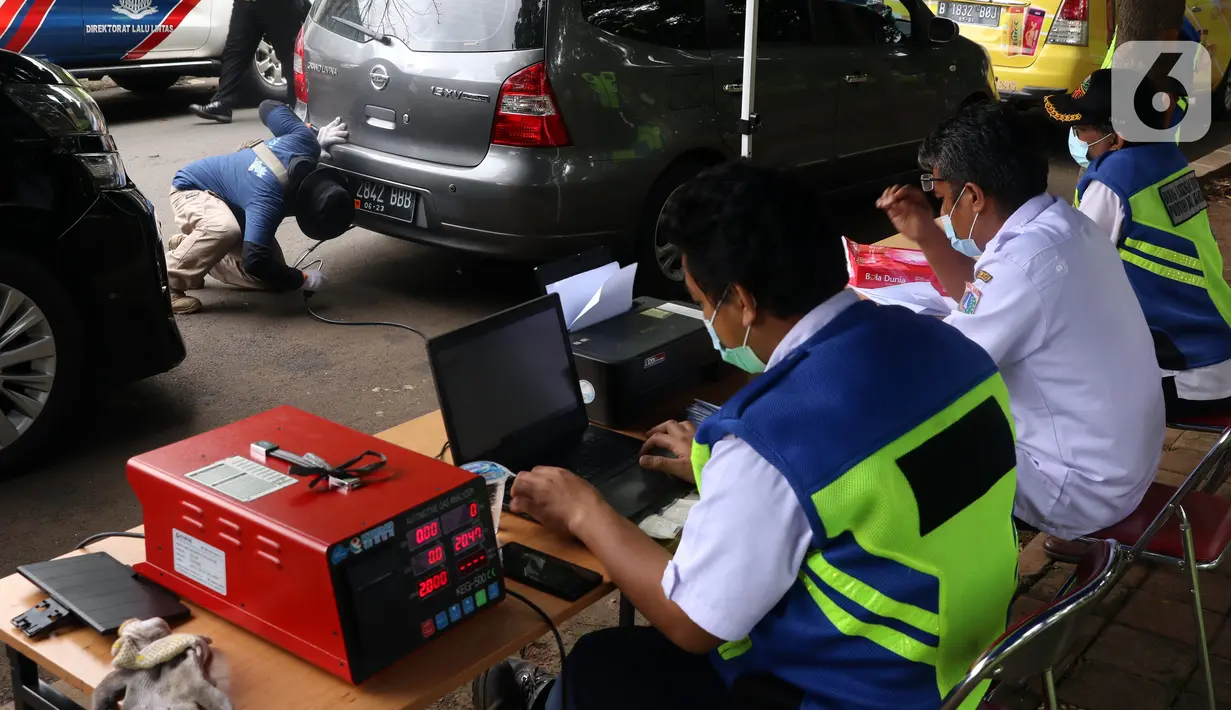 Petugas memeriksa emisi kendaraan di Jakarta Barat, Rabu (13/1/2021). Dinas Lingkungan Hidup DKI Jakarta mengumumkan kendaraan yang tidak mengikuti uji emisi atau tidak lulus uji emisi gas buang akan dikenakan disinsentif tarif parkir yang tinggi dan tilang. (Liputan6.com/Angga Yuniar)