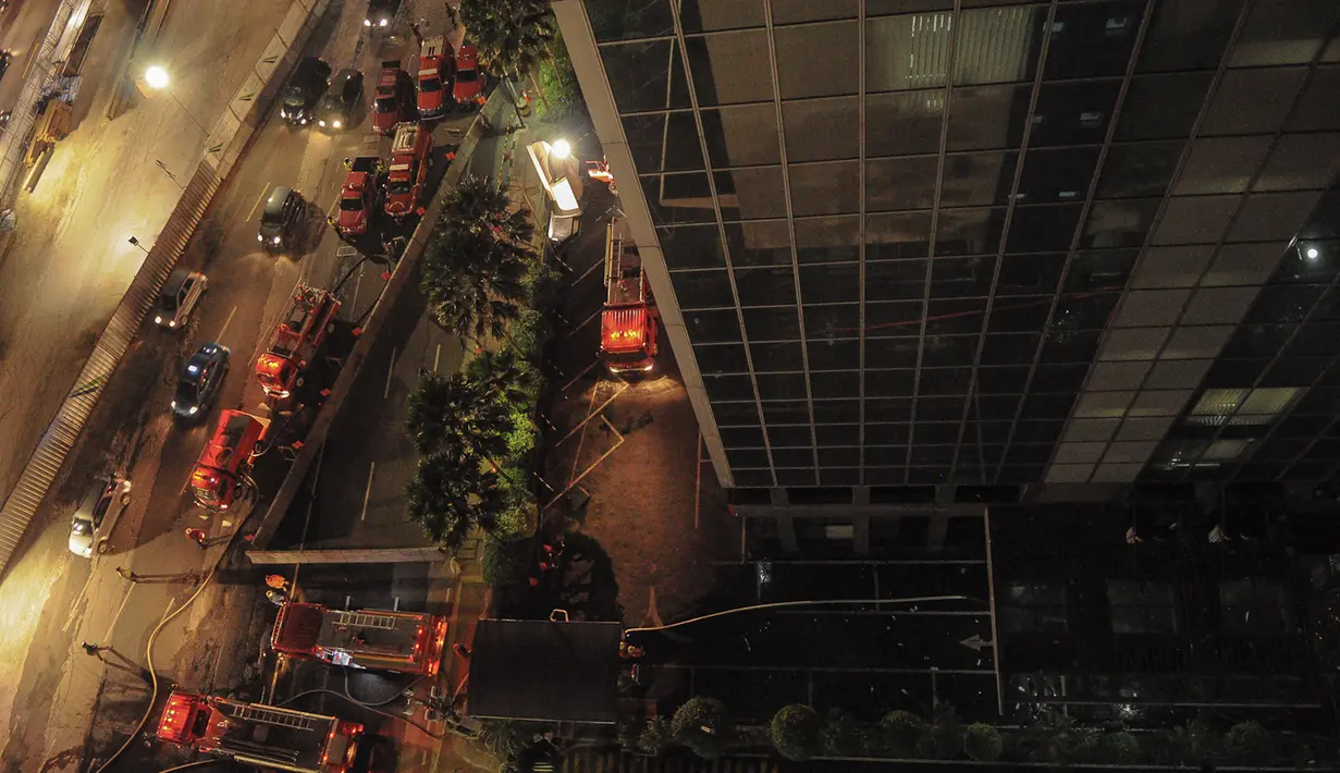 Dinas Pemadam Kebakaran DKI Jakarta menerjunkan 23 mobil pemadam kebakaran ke lokasi kebakaran di Wisma Kosgoro, Jalan MH Thamrin, Jakarta Pusat, Senin (9/3/2015).(Liputan6.com/Faizal Fanani)