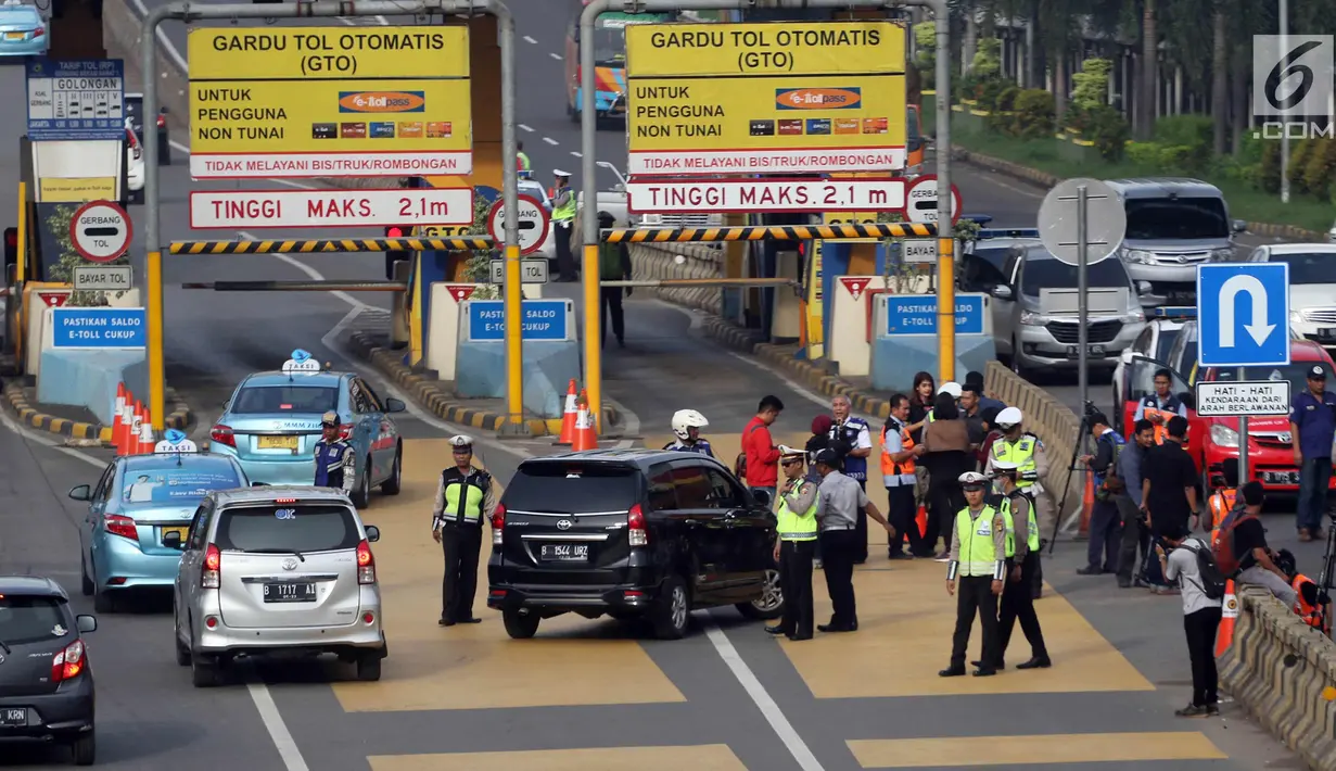 Petugas mengarahkan kendaraan berplat genap berputar balik di Gerbang Tol Bekasi Barat 1, Bekasi, Jawa Barat, Selasa (13/3). Hari kedua penerapan ganjil genap, masih banyak kendaraan berputar balik di gerbang tol tersebut. (Liputan6.com/Arya Manggala)