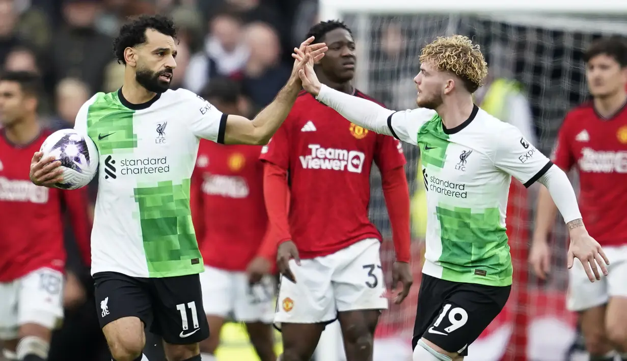 Selebrasi striker Liverpool, Mohamed Salah (kiri) bersama rekannya, Harvey Elliott usai mencetak gol penyeimbang 2-2 ke gawang Manchester United lewat eksekusi penalti pada laga pekan ke-32 Premier League 2023/2024 di Old Trafford Stadium, Manchester, Minggu (7/4/2024). (AP Photo/Dave Thompson)