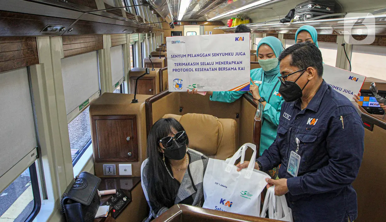 Petugas memberikan bingkisan kepada penumpang KA Taksaka di Stasiun Gambir, Jakarta, Sabtu (4/8/2021). Dalam rangka memperingati hari pelanggan nasional, PT KAI Daop 1 Jakarta membagikan ratusan bingkisan kepada penumpang kereta api. (Liputan6.com/Faizal Fanani)