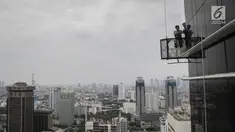 Pekerja tanpa helm keselamatan beraktivitas di gedung bertingkat di Jakarta, Rabu (15/11). Banyak kejadian kecelakaan kerja di ketinggian disebabkan karena minimnya pengetahuan dasar mengenai keselamatan kerja di ketinggian. (Liputan6.com/Faizal Fanani)